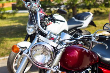 Güneşin altında güzel bir Burgonya motosikleti. Krom direksiyon simidi.