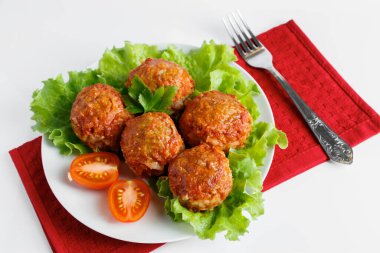 Domates soslu sebzeli ev yapımı protein köfteleri. Beyaz tabakta iştah açıcı sıcak yemek..