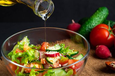 Sebze salatası hazırlama süreci. Mevsimlik yaz yemekleri, siyah arka planda vejetaryen yemekleri..