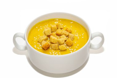 Beyaz arka planda izole edilmiş balkabağı kremalı çorba. Beyaz arka planda beyaz bir bulyon içinde beyaz krakerli balkabağı kremalı çorba.