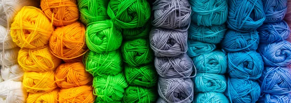 Many balls of wool yarn for knitting. Selling fluffy threads in a craft store. Banner format