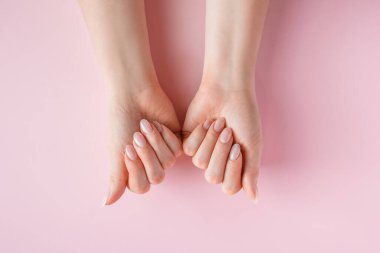 Deri bakımı konsepti. Pembe arka planda güzel kadın elleri. Metin için yer