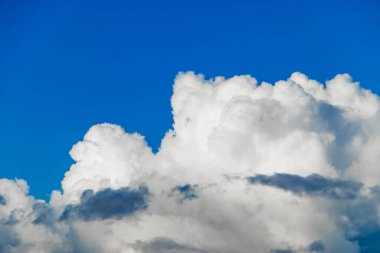 Beyaz tüylü kümülüs bulutları açık mavi gökyüzüne karşı. Uçaktan en iyi görüntü. Tasarım için arkaplan.