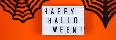 Mutlu Cadılar Bayramı. Turuncu arka planda tatil için kağıt dekor. Sancak biçimi