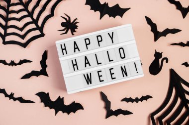 Cadılar Bayramı konsepti Pembe arka planda yarasalar ve örümcekler. Şenlikli dekorasyonlar.