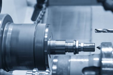 Cnc torna makinesi veya çelik şaft kısmında delik delme torna makinesi. Modern üretim süreci.