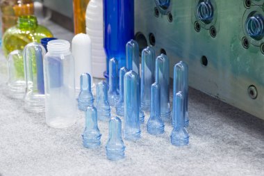 Çeşitli tip plastik şişe ürünü ve enjeksiyon kalıplı preform malzeme. İçme kabı üretim işlemi.