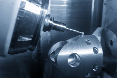 5 eksenli Cnc freze tezgahı veya işleme merkezi katı topu frezeler aracıyla Otomotiv bölümü ışık mavi sahnede kesme. Hi-teknoloji üretim süreci.