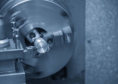 Torna makinesi ışık mavi sahnede çelik şaft kesme işlemi.