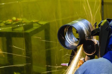 İnşaat işçisi el değirmeni çelik boru zımpara kullanın. İnşaat işçisi endüstri pratiği.