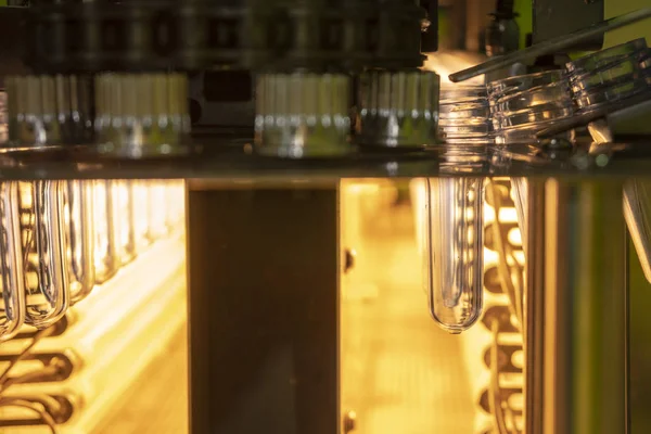 The  preform shape of plastic bottles in the heater conveyor