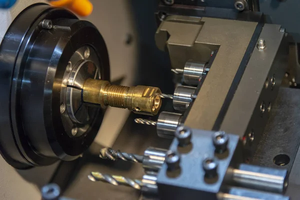 The CNC lathe machine drilling the hole on the brass  shaft part — Stock Photo, Image
