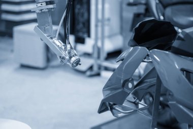 Motosiklet parçalarını püskürten boyama robotu. 