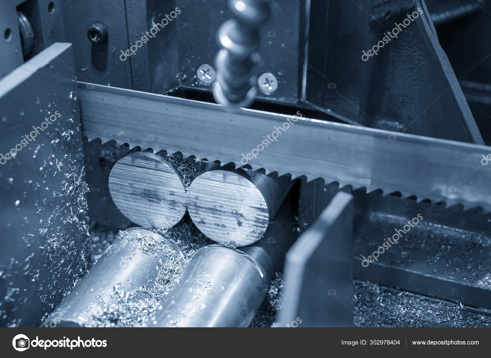 The operation of band saw machine cutting the metal rod. Stock Photo by