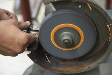 Beceri operatörü matkap aletinin yeniden öğütülmek için elini kullanır .