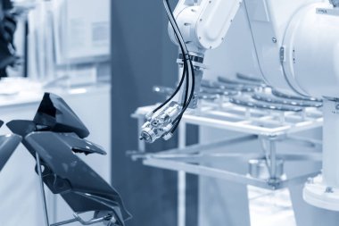 Boyalı robot kol boyayı püskürtüyor. .