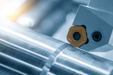 CNC torna makinesinin yakın çekim kesim aracı. Çip açma aracı. CNC torna makinesi metal şaft parçalarını kesiyor..