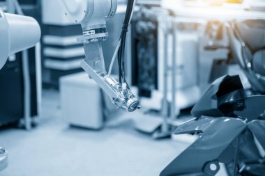 Boya robotu motosiklet maskesi parçalarına yeşil renk püskürtüyor. Robot sistemi tarafından otomotiv parçaları boyama sistemi. 