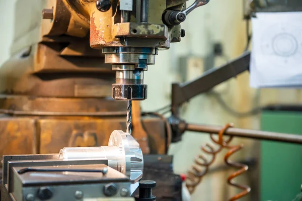 The milling machine drilling the hole on aluminium shaft part by drill tools. The metal working process by NC milling machine.