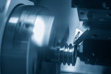 CNC torna makinesi, metal makara parçalarını kesiyor. CNC dönüşüm makinesinin yüksek teknolojili metal işlemesi .