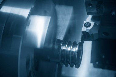 CNC torna makinesi, metal makara parçalarını kesiyor. CNC dönüşüm makinesinin yüksek teknolojili metal işlemesi .