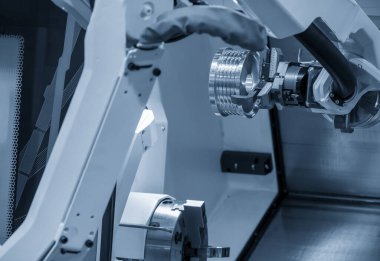 Yüksek teknolojili CNC robotik sistemli torna makinesi. Robotik sistem tarafından otomotiv parçaları üretim süreci konsepti.