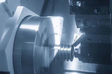 CNC torna makinesi, metal makara parçalarını kesiyor. CNC dönüşüm makinesinin yüksek teknolojili metal işlemesi .