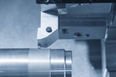 CNC Torna Makinesi sahnesini kapatın. Mavi ton sahnesindeki metal şaft parçalarını kesin. CNC dönüşüm makinesi tarafından çalışan yüksek teknolojili metal işleme .