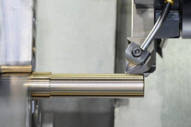 CNC torna makinesi, metal şaft parçalarını kesmiş. Yüksek duyarlı metal işleme süreci dönerek çalışır.