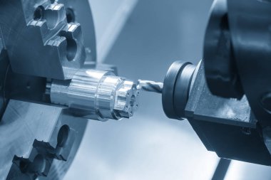 CNC, metal şaft parçaları üzerine makine sondaj işlemi merkezi delme aracı mavi tonda. CNC dönüşüm makinesiyle çalışan yüksek teknoloji metali.