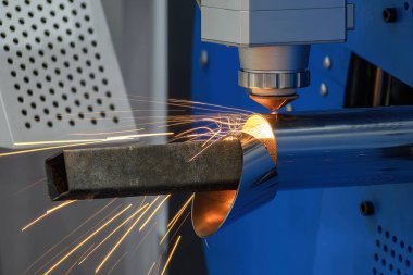 Sahneyi kapatın, fiber lazer kesme makinesi paslanmaz çelik tüpü parlak ışıkla kesti. Lazer kesme makinesinin yüksek teknoloji metal üretim süreci.. 