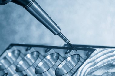  5 eksenli CNC değirmen makinesi tarafından üretilen otomotiv parçaları. 5 eksenli CNC değirmen makinesi açık mavi sahnede alüminyum motor bloğunu sert top burun değirmeni aracıyla kesiyor.