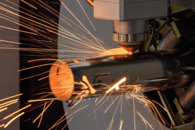 Lif lazer kesme makinesi paslanmaz çelik boruyu oyuyor. Lazer kesme makinesinin parlak ışığı.