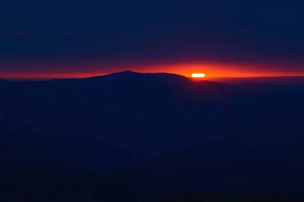 Red sun rises in mountains