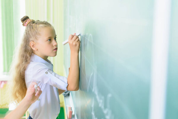 School girls paint on board and have fun in classroom