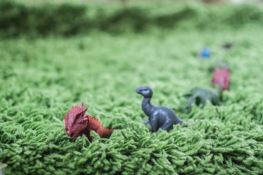 Yüksek otların minyatür yaban hayatı Toy dinozorlar