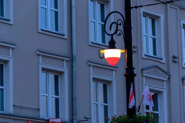 Polnische Flagge farbige Laternenpfahl am Abend, — Stockfoto