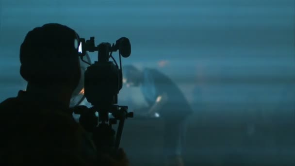 夜のシルエットシーンビデオグラファーでDJセットコンサートを撮影するビデオオペレーター — ストック動画
