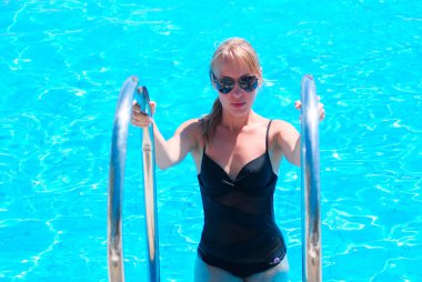 Aqua Park 'taki havuzda dinlenen beyaz sarışın, yaz tatili.