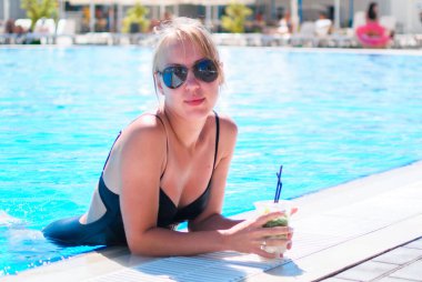 Aqua Park 'taki havuzda dinlenen beyaz sarışın, yaz tatili.