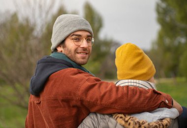 Güzel bir sonbahar gününde doğada romantik bir yürüyüş yapan genç çiftin arka görüntüsü.