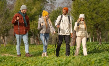 Dört mutlu yürüyüşçüden oluşan çok ırklı bir grup güneşli bir günde kuzeyli yürüyüş maceralarının tadını çıkarıyorlar.