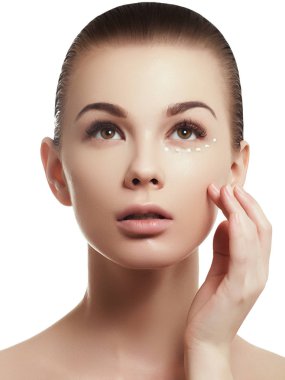 Güzel kız onun yüzüne cilt bakımı için biraz krema uygulamak. Gençlik ve cilt bakım kavramı. Kadın güzellik yüz portre sağlıklı cilt ile beyaz izole. Mükemmelsin yüzü ile spa kadın portre