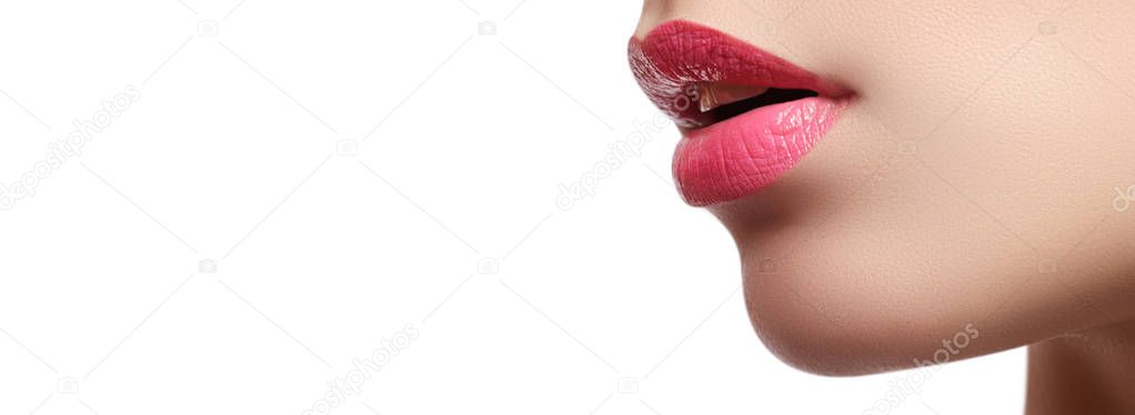 Close-up of woman's lips with bright fashion pink glossy makeup. Macro magenta lipgloss make-up. Sexy pink lip makeup. Highly saturated color. Lipstick