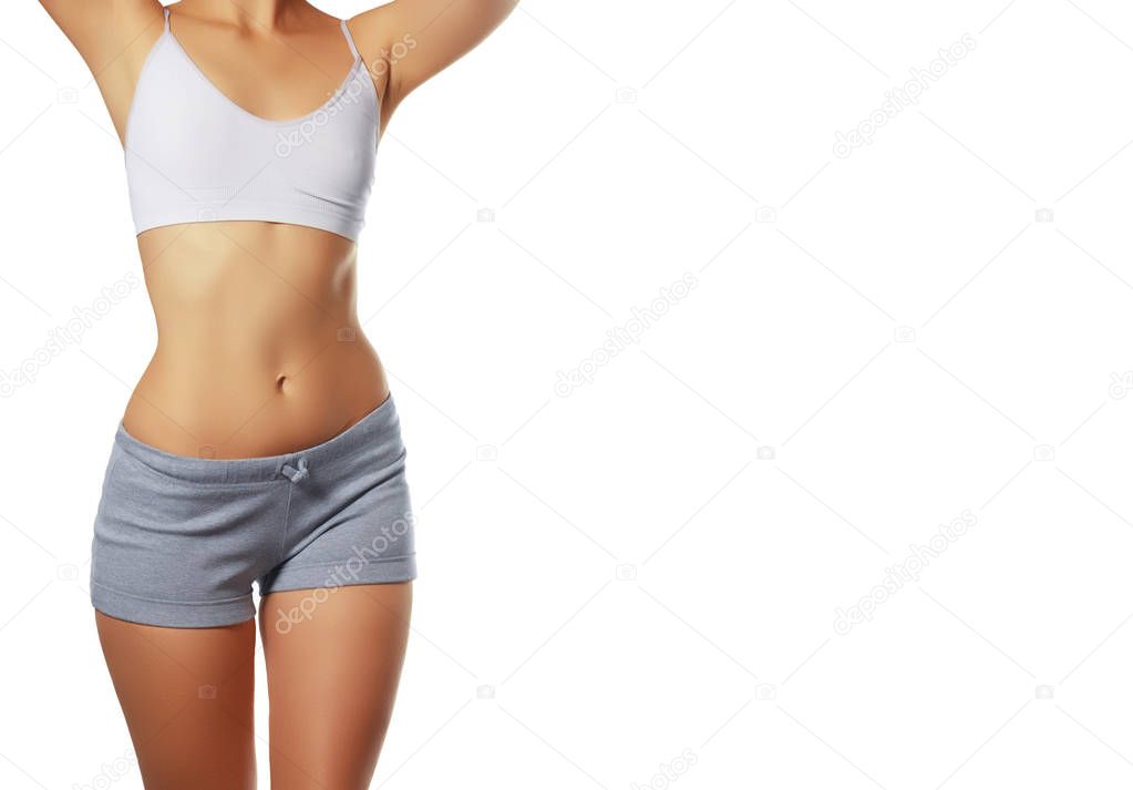sporty girl in black bikini posing on white background. Photo of attractive girl with slim toned body. Beauty and body care concept