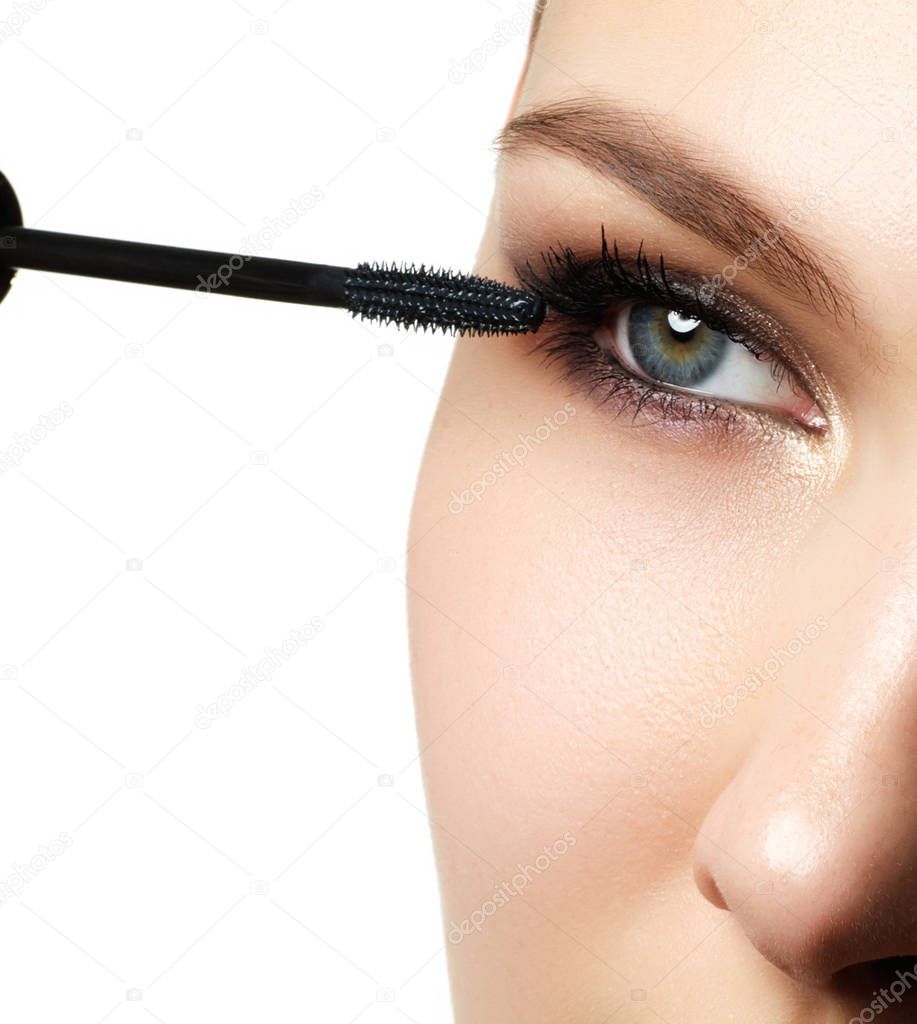 Mascara applying closeup, long lashes. Mascara brush. Eyelashes extensions. Make-up for blue eyes. Eye make up apply. Woman eye with beautiful makeup and long eyelashes. Mascara Brush