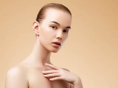 Cilt Bakımı. Güzellik Spa kadın mükemmel cilt portre ile. Güzel Spa kız. Bir ürün öneriyor. Reklam için hareketler. Bej renkli arka plan