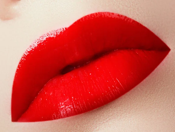 Cosmetics, makeup and trends. Bright lipstick on lips. Closeup of beauty female mouth with red lip makeup. Beautiful part of female face. Perfect clean skin