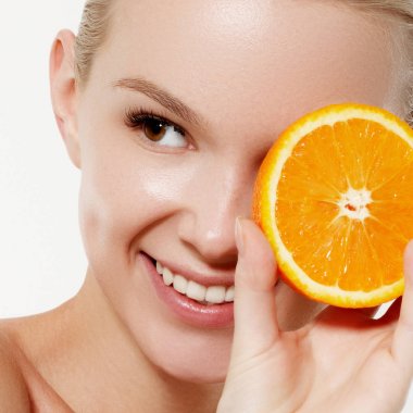 Taze meyve ile gülümseyen kız. Güzellik modeli sulu portakal alır. Çiller ile neşeli kız. Sağlıklı bir diyet kavramı. Profesyonel makyaj. Portakal dilim