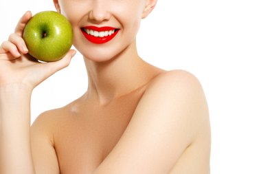 Sağlıklı bir diyet yemek. Güzel mutlu gülümseyen genç kadın ile mükemmel bir gülümseme, beyaz dişler ve taze yüz organik yeşil elma tutan closeup portresi. Diş sağlığı kavramı. Yüksek çözünürlüklü görüntü